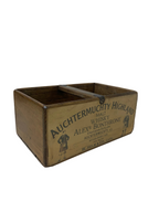Vintage wooden crate with 'Auchtermuchty Highland' branding on a concrete floor.