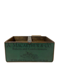 Vintage wooden box with 'A. Macarthur & Co.' branding on a light wooden floor.